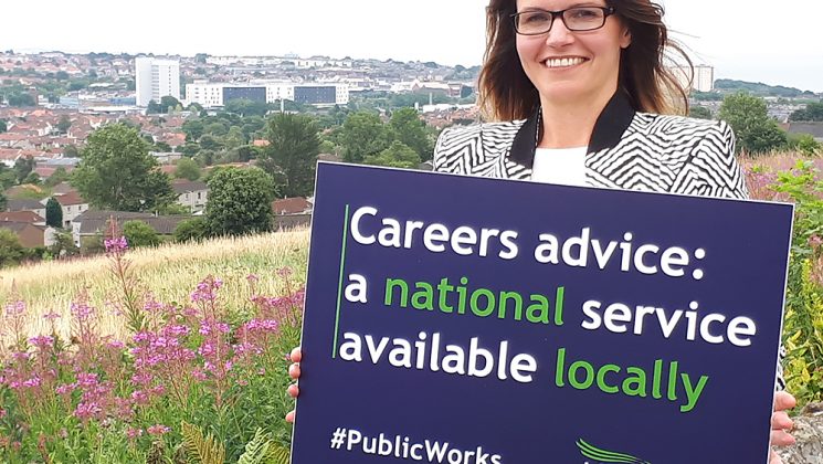 Scottish careers advice members on a hill above Fife holding a placard reading: Careers Advice – a national service provided locally