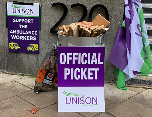 Official picket placard in front of a brazier